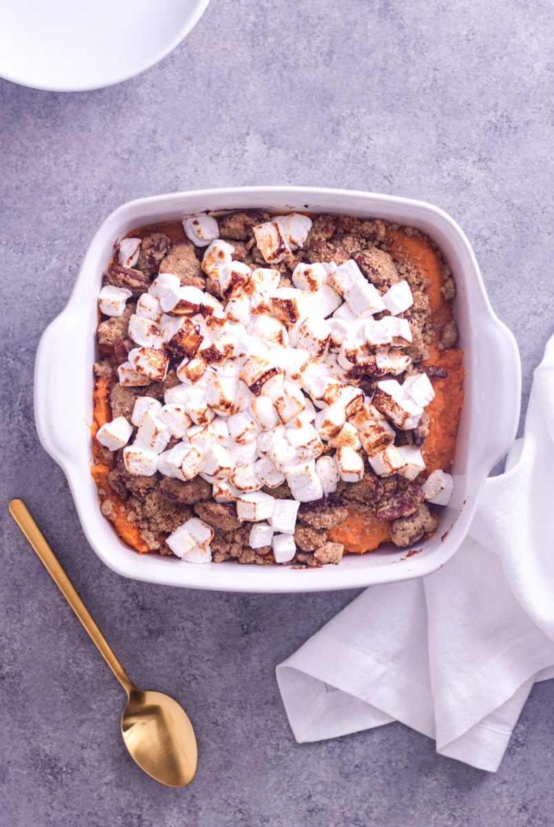 Overhead view of sweet potato casserole with marshmallows and brown butter pecan topping in a casserole dish.