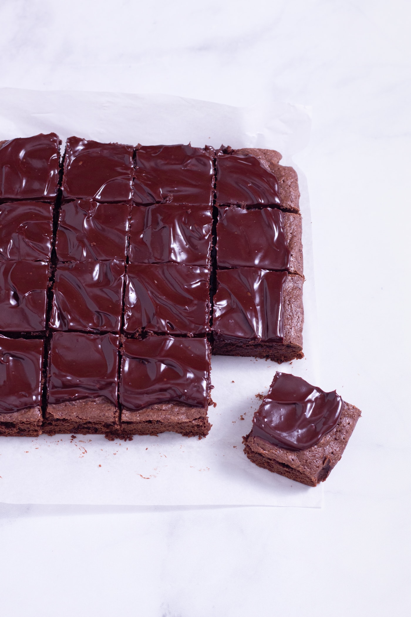 Slightly angled above view of fudgy, sliced red wine brownies with ganache.