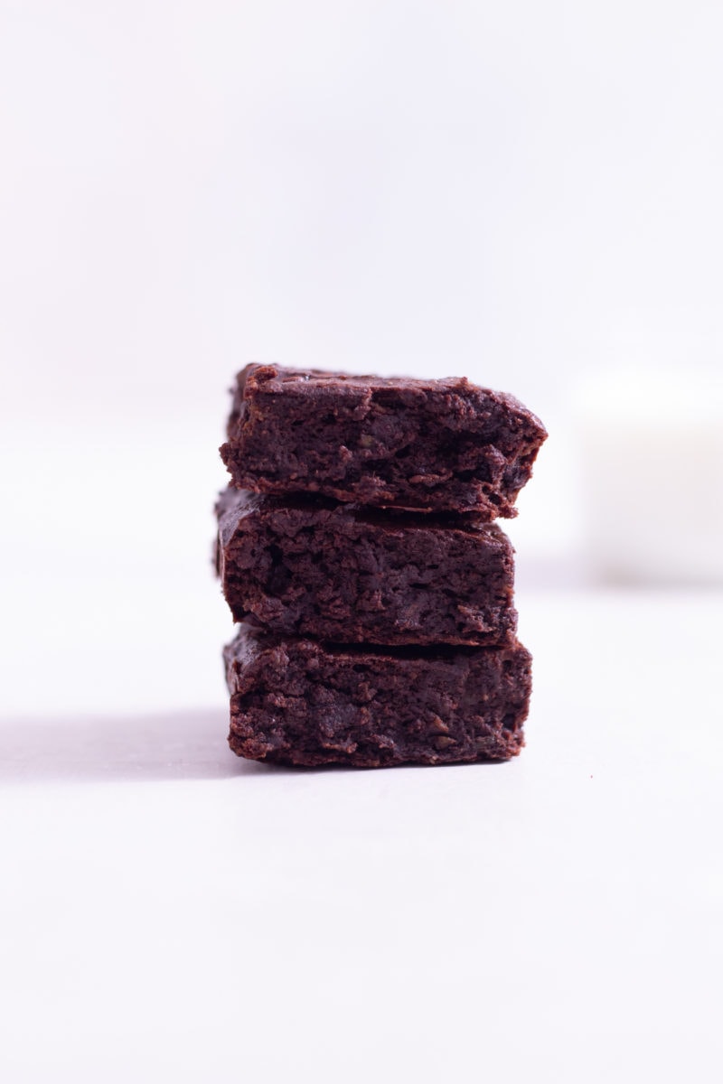 Straight on view of a stack of healthy brownies on a white background.