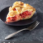 Angled view of a slice of strawberry rhubarb pie on a dark plate on a dark grey surface.