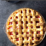 Strawberry Rhubarb Pie overhead on dark grey surface.