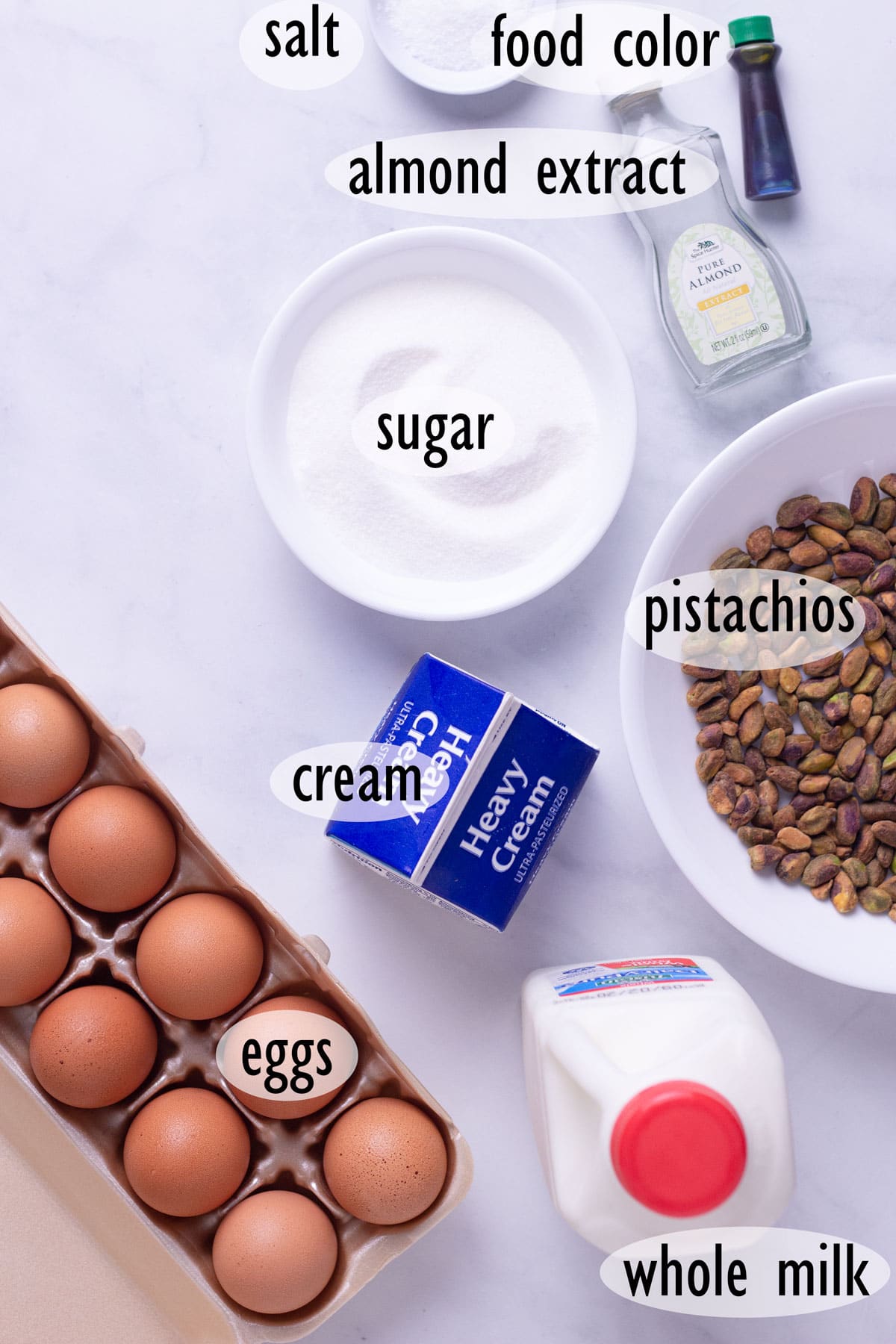 Individual ingredients needed for this recipe, including pistachios, eggs, cream, milk and sugar.