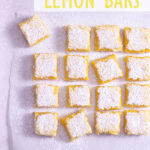 Overhead, zoomed out view of cut lemon bars on parchment.