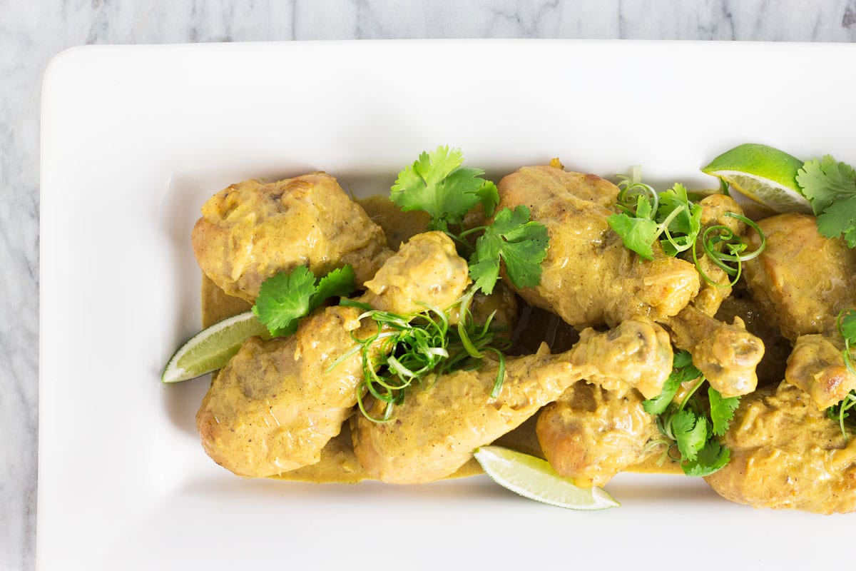 Overhead, closeup view of a platter of Curry Chicken Legs.