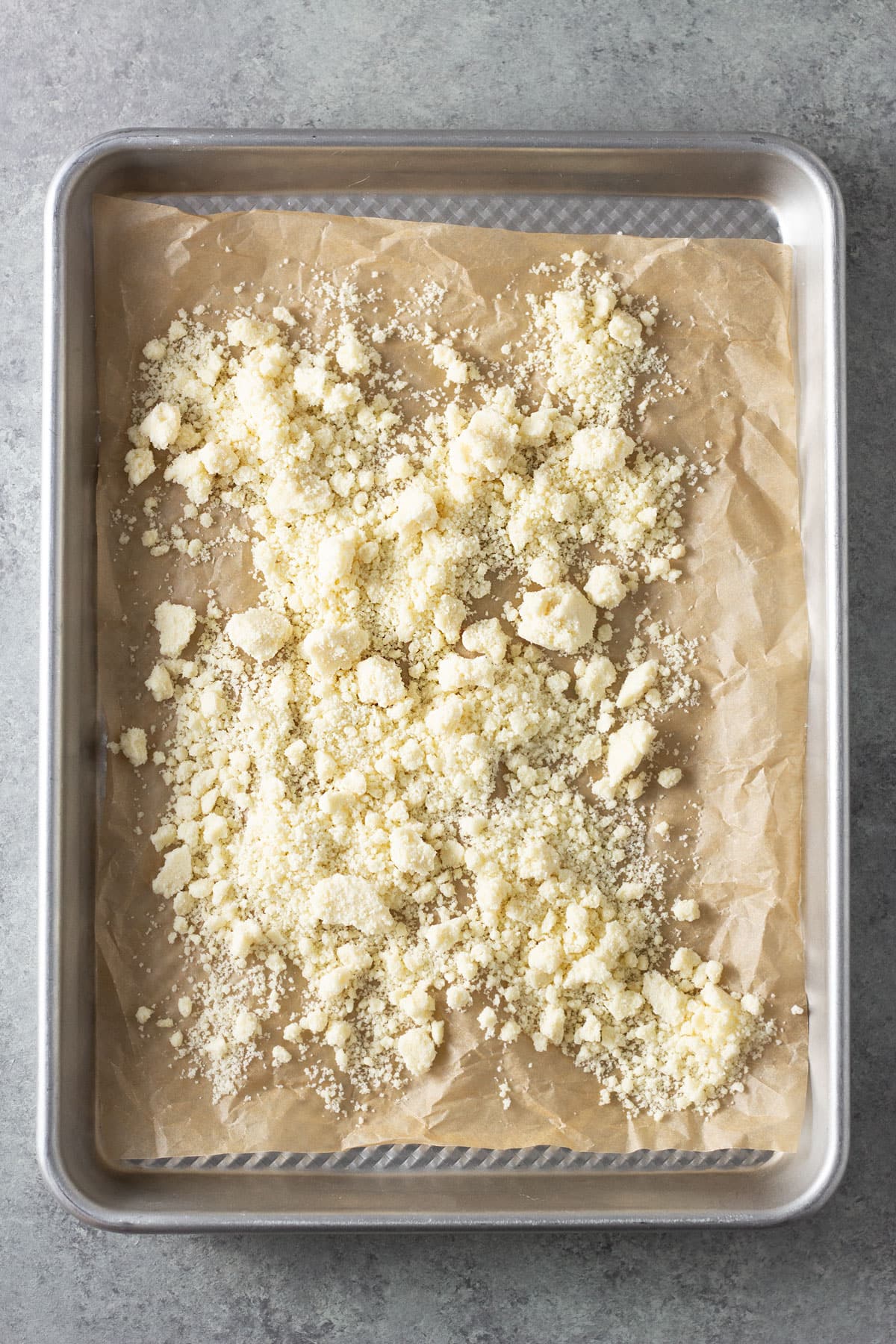 Overhead view of a sheet tray of powdered milk crumble.