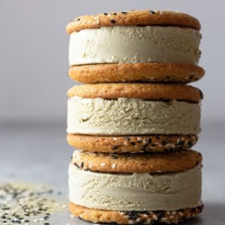 Straight on view of a stack of three matcha ice cream sandwiches on tahini sesame cookies.