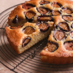 Angled, close up view of Fig and Almond Cake on a rustic wire cooling rack.