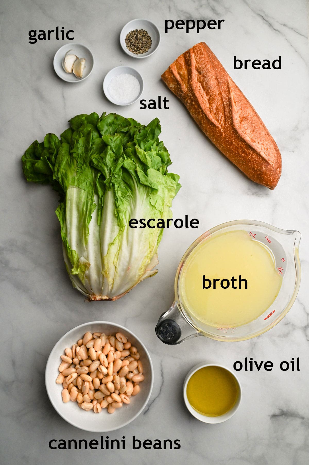 Recipe ingredients, including escarole, cannellini beans, garlic, olive oil, broth and bread.