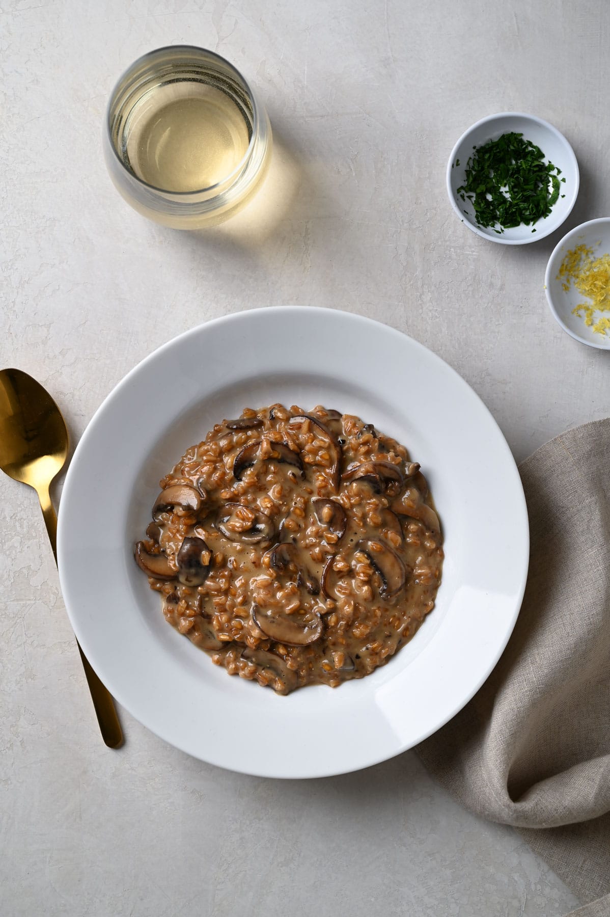 Overhead view of a bowl of Mushroom Farro Risotto freshly scooped into a serving bowl without any toppings.
